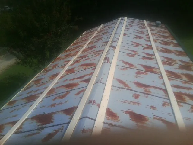 Rusted metal roof panels with new wood purlins before replacement — Storm Damage Roof Repair in Ronald by Roofing Brothers