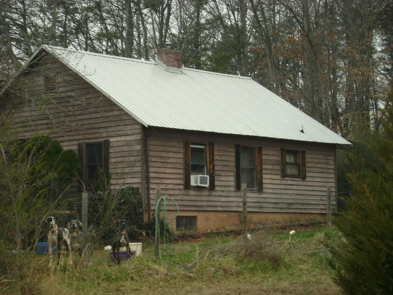 White metal roof on an old wood sided farmhouse, from a Metal Roof Installation job in Ronald